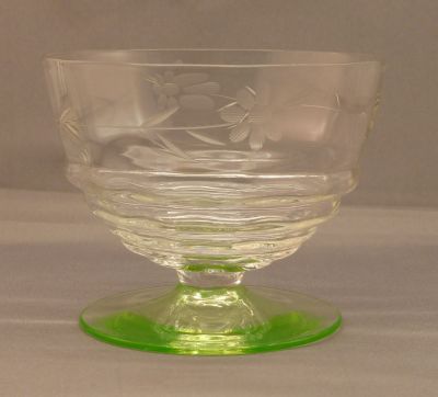 Engraved dessert bowl with uranium foot
Vertical optic rib pattern to bowls and horizontal ribbing at base. Heat finished rims. Likely English. Lead crystal ring. 4 in. diameter, 3 in tall. 
Keywords: blown;table;sold